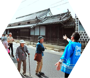 団体の観光客を案内する青い法被を着た男性