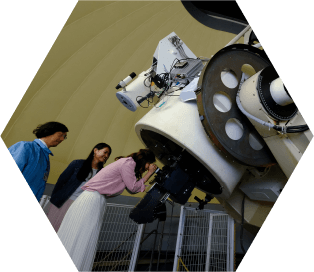 天体望遠鏡を覗き込む女性